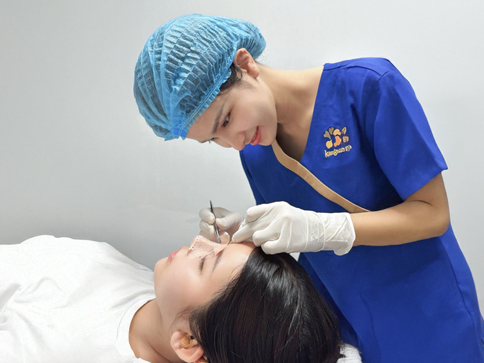 điều dưỡng tại Kangnam đang cắt chỉ cho khách hàng nâng mũi