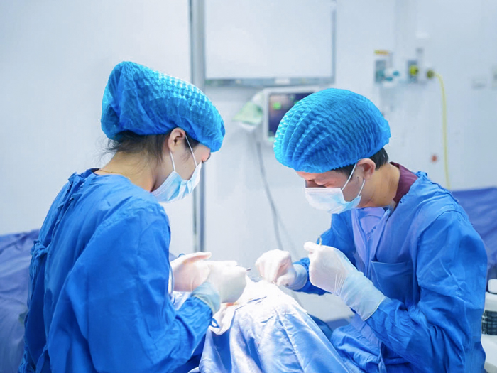 Bác sĩ chuyên khoa phẫu thuật chỉnh hình sụp mi cho khách hàng trong phòng thủ thuật vô khuẩn