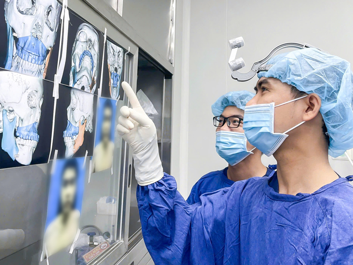bác sĩ Hảo phân tích phim X-quang để lên phương án tối ưu cho khách hàng