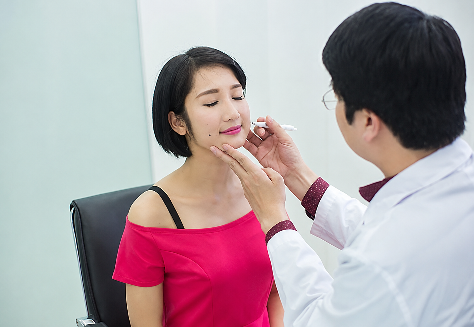 bác sĩ Kangnam đang thăm khám và đánh dấu vùng tạo má lúm cho khách tại Kangnam