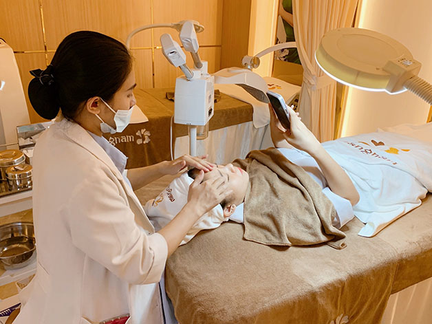 bác sĩ da liễu vệ sinh da và chuẩn bị thực hiện điều trị mụn cho khách hàng
