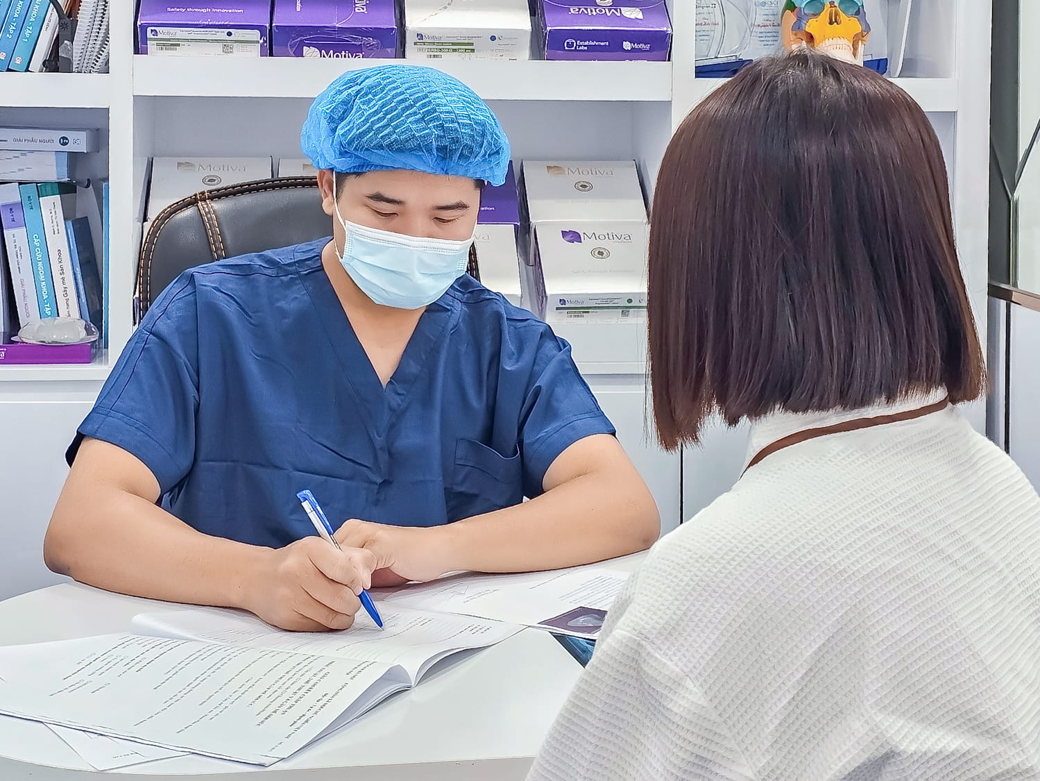 bác sĩ tư vấn cho khách hàng và kiểm tra sức khỏe trước khi tháo túi