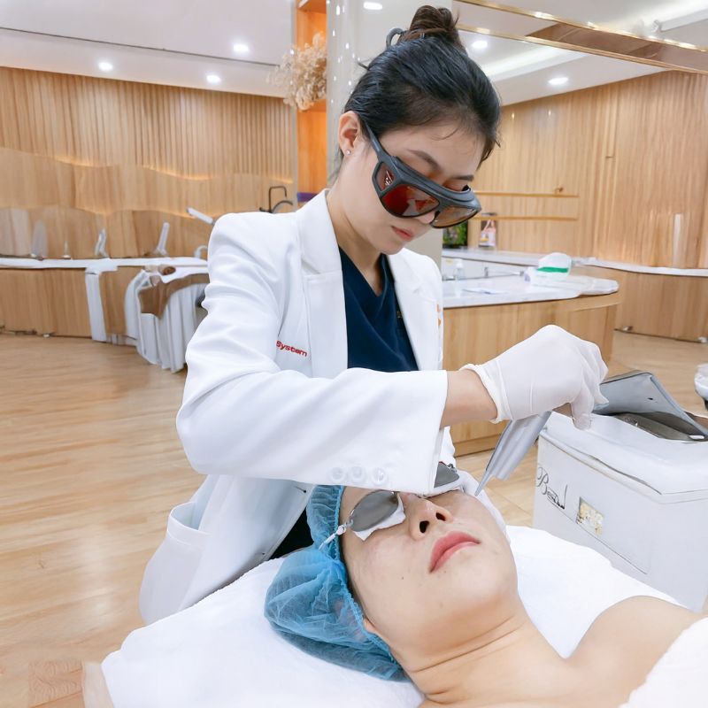 bác sĩ bắn tia laser điều trị sau mụn cho khách hàng