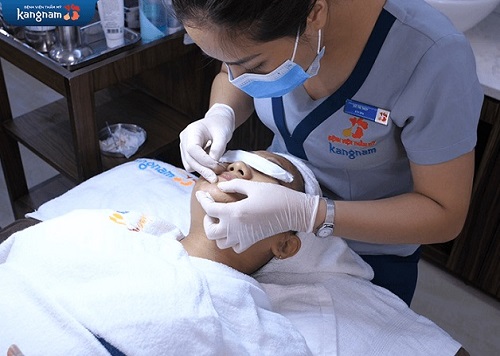 Kỹ thuật viên nặn mụn cho khách hàng