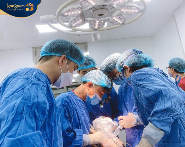 Bác sĩ phẫu thuật và đưa chất liệu độn vào vùng cằm bị lẹm