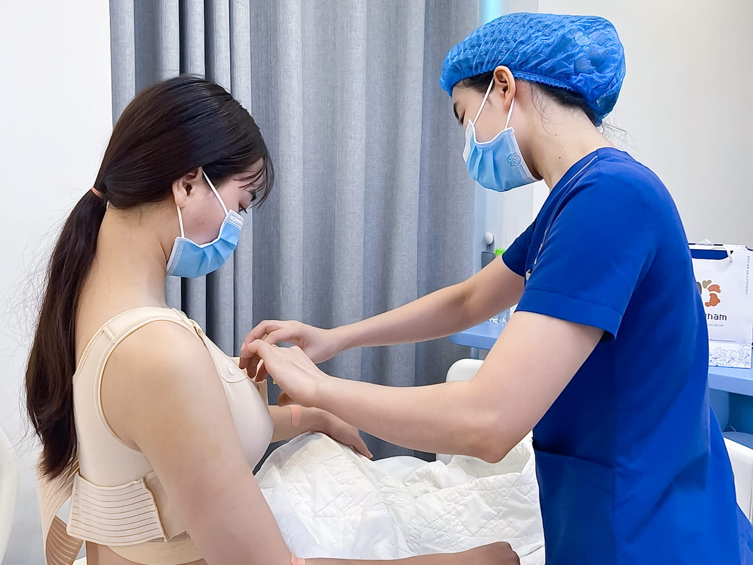Khách hàng được theo dõi tại phòng hậu phẫu hiện đại, điều dưỡng hướng dẫn mặc áo ngực tỉ mỉ
