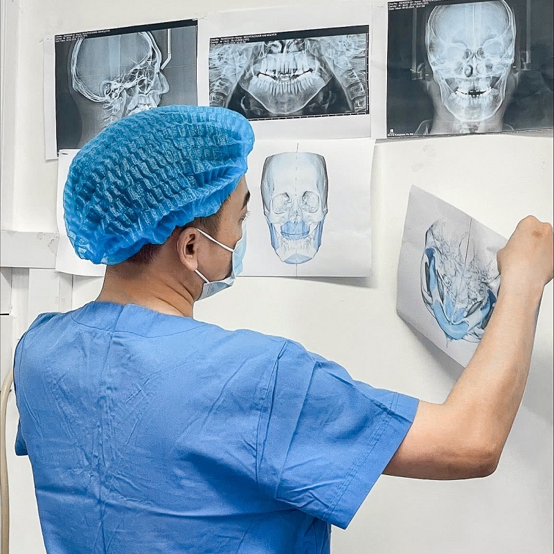 Bác sĩ xem kết quả chụp Xquang của khách hàng để lên kế hoạch phẫu thuật