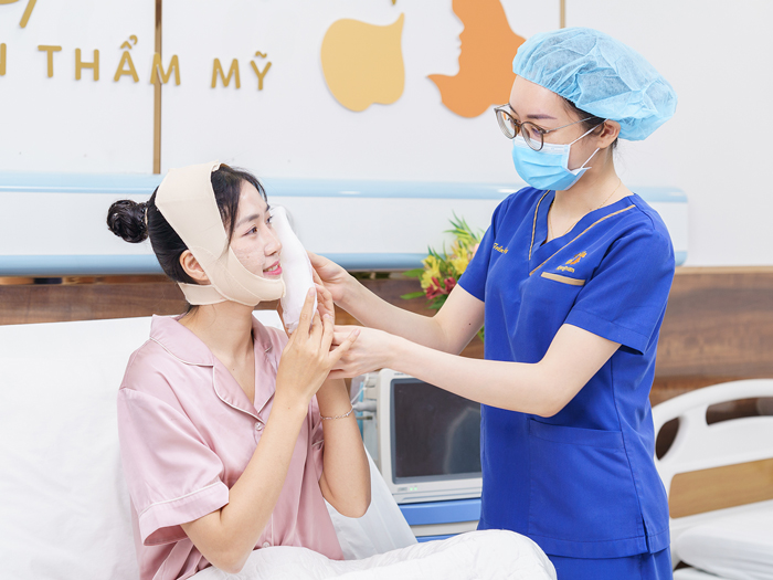 Khách hàng đeo băng ép và chườm lạnh để gương mặt nhanh giảm sưng