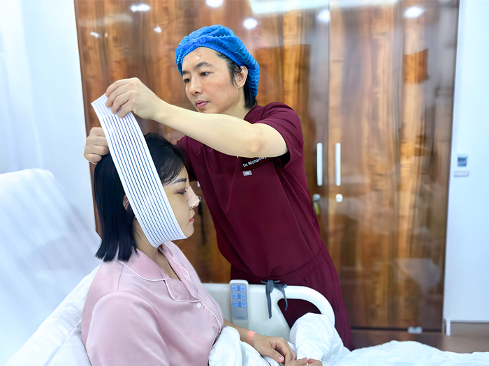 bác sĩ hướng dẫn chăm sóc hậu phẫu gọt hàm, đeo băng ép cho khách hàng