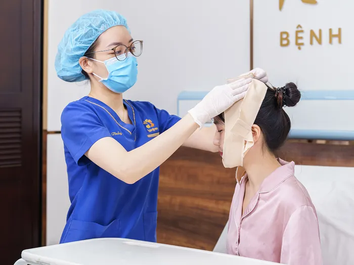 Khách hàng đeo băng ép định hình sau phẫu thuật hạ gò má tại bệnh viện thẩm mỹ.