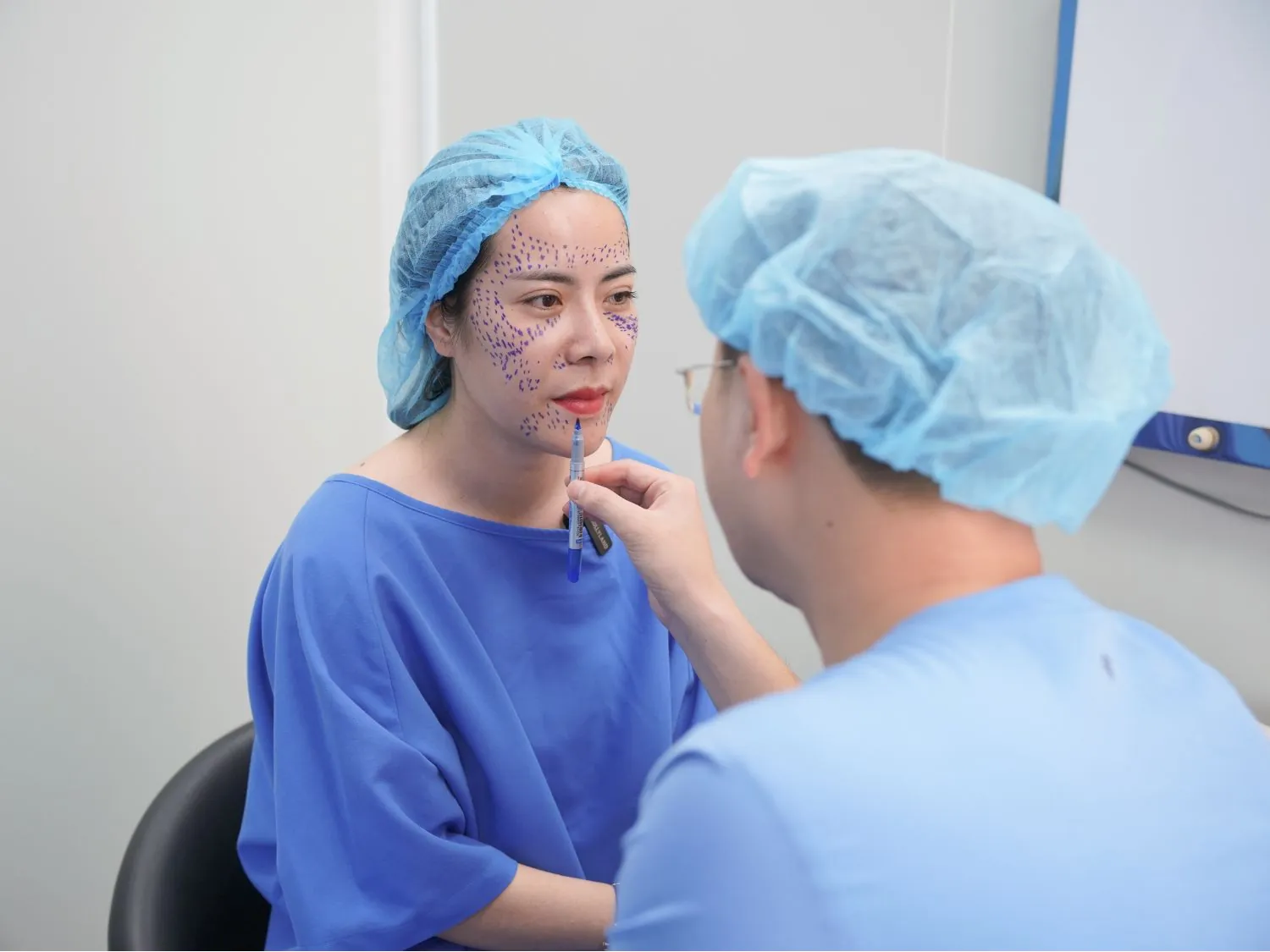 Bác sĩ phác thảo, đánh dấu vị trí cần cấy mỡ cho khách hàng