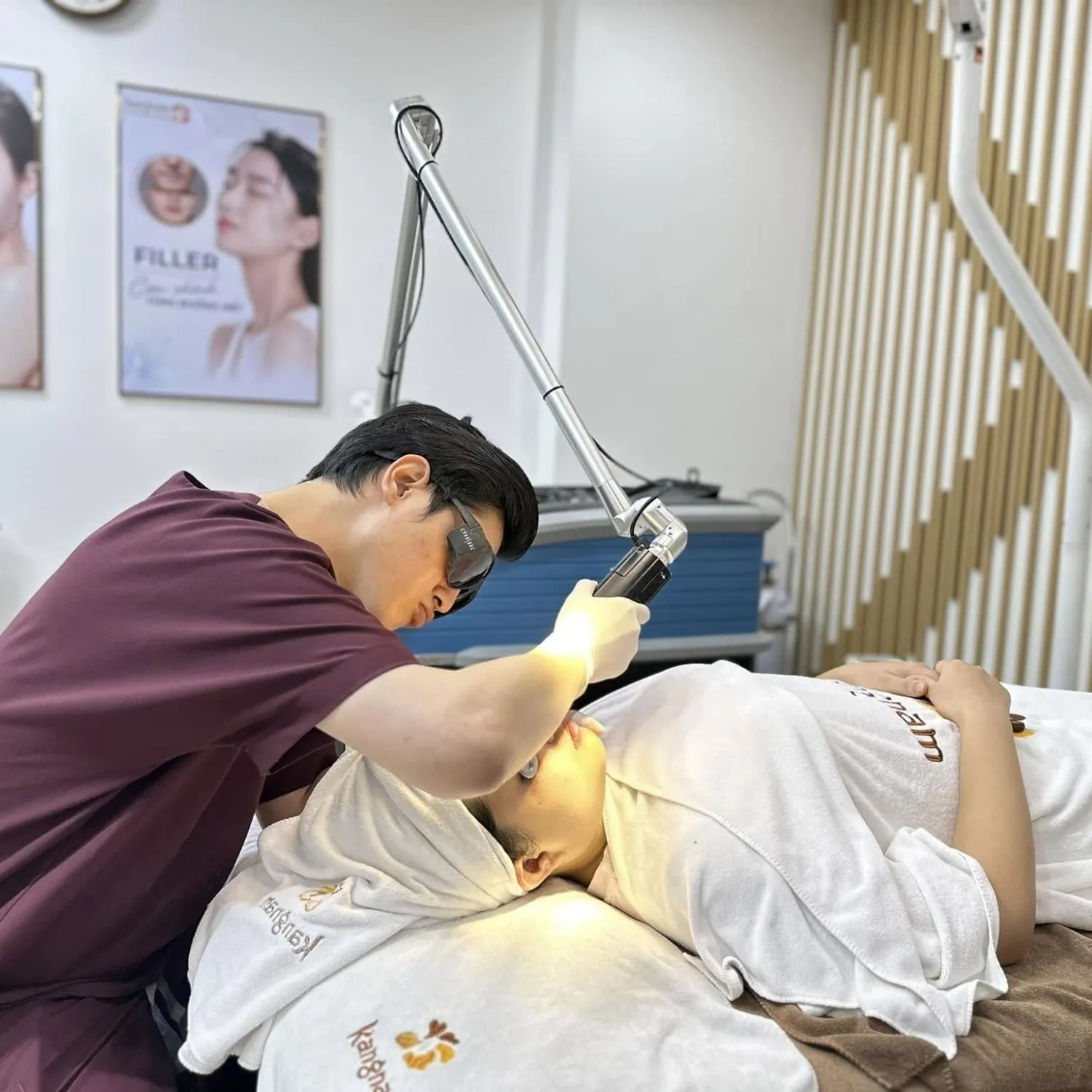 bác sĩ dùng thiết bị công nghệ hiện đại điều trị da cho khách