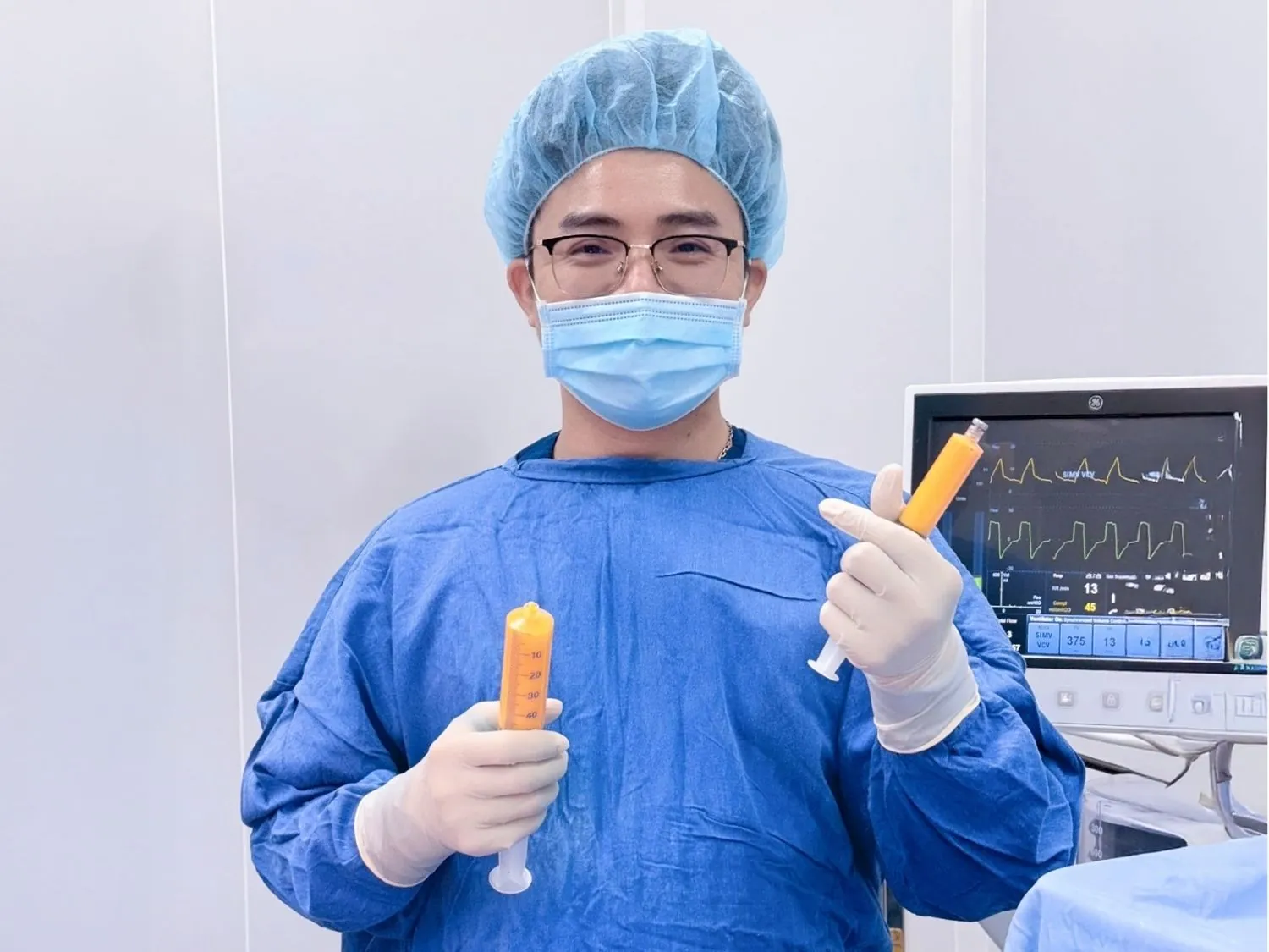 Bác sĩ cầm ống hút mỡ trong phòng vô trùng